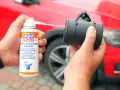 Czyszczenie przepływomierza: ręka trzyma puszkę preparatu Liqui Moly i aplikuje go na element.